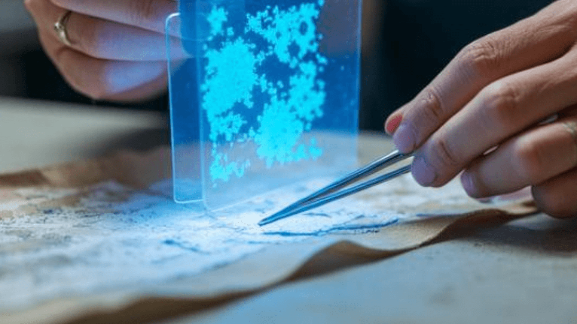 Alter Stoff wird von einer Restauratorin untersucht, ein Hologram unterstützt
